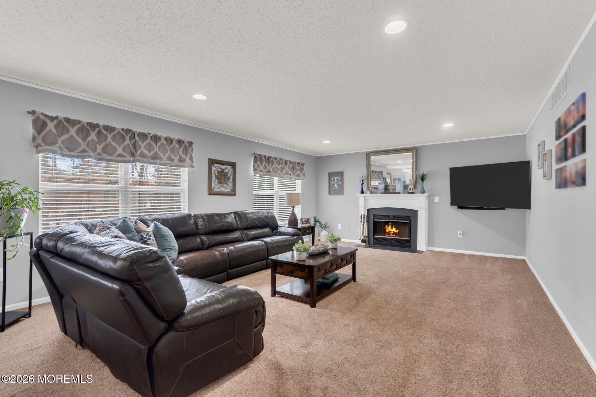 93 West Shenendoah Road Howell, NJ 07731 - Photo 9 of 30 a living room with furniture a flat screen tv and a fireplace