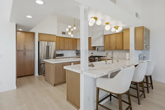 a kitchen with kitchen island a sink stove and refrigerator
