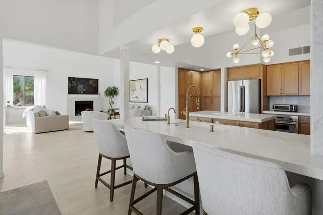 a large white kitchen with a large island in the center and a faucet