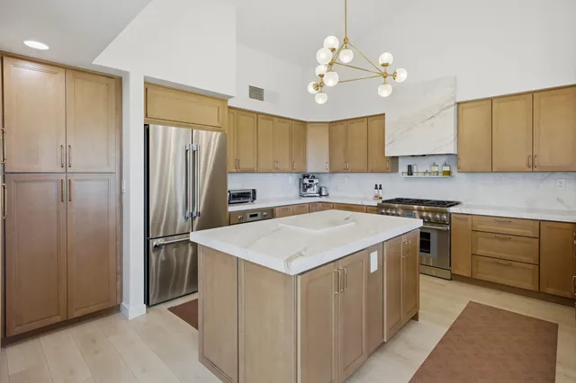 a kitchen with a refrigerator a sink cabinets and a window