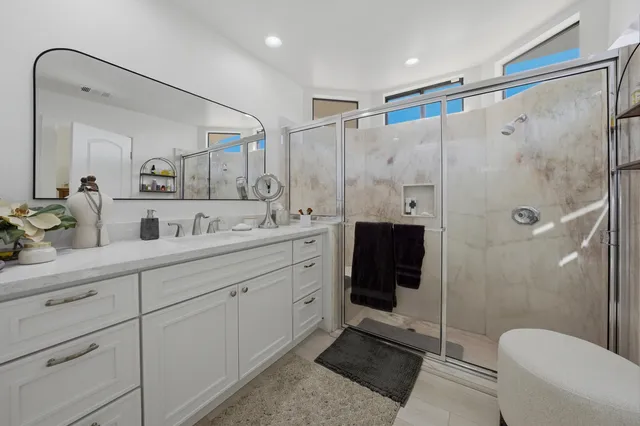 a spacious bathroom with a shower sink mirror and toilet