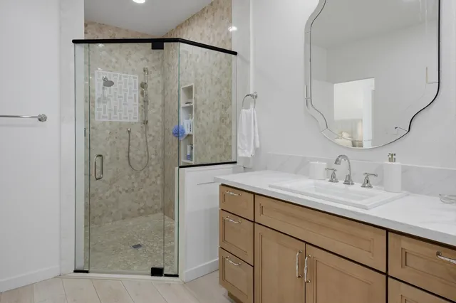 a bathroom with a granite countertop sink a shower and a mirror