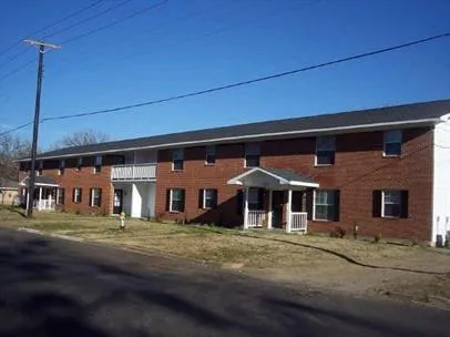 a front view of a building with large trees