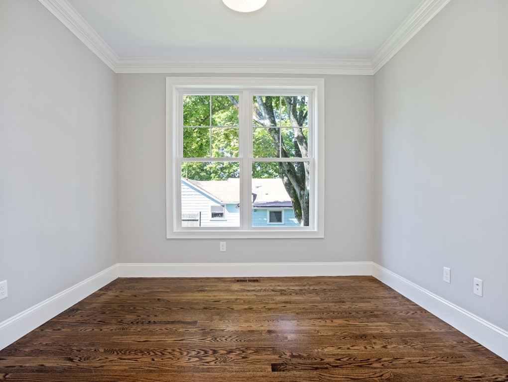 25 Larkin Road Newton, MA 02465 - Photo 7 of 27 an empty room with wooden floor and windows