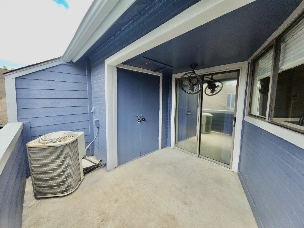 2500 Burleson Road, Unit 521 Austin, TX 78741 - Photo 20 of 20 Outdoor balcony with concrete flooring, dark blue horizontal panel siding, and a built-in storage closet with matching dark blue doors