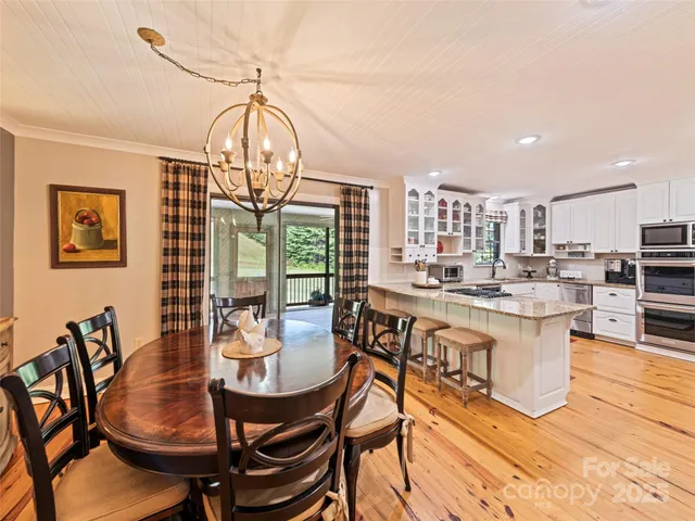 a view of a dining room with furniture a chandelier and wooden floor