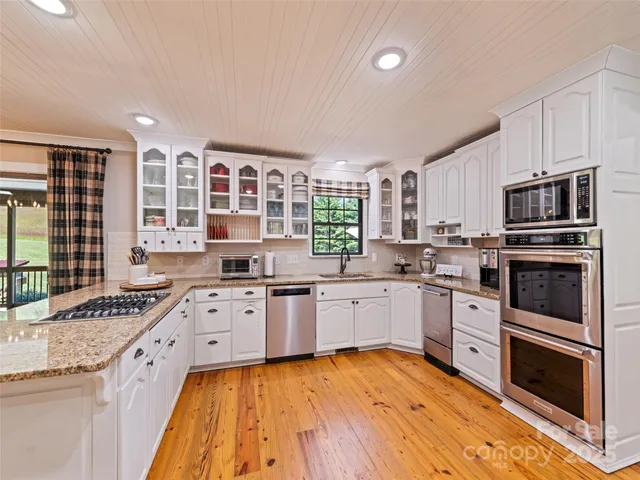 a kitchen with stainless steel appliances granite countertop a stove sink and cabinets