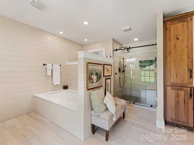 a bathroom with a tub shower and mirror