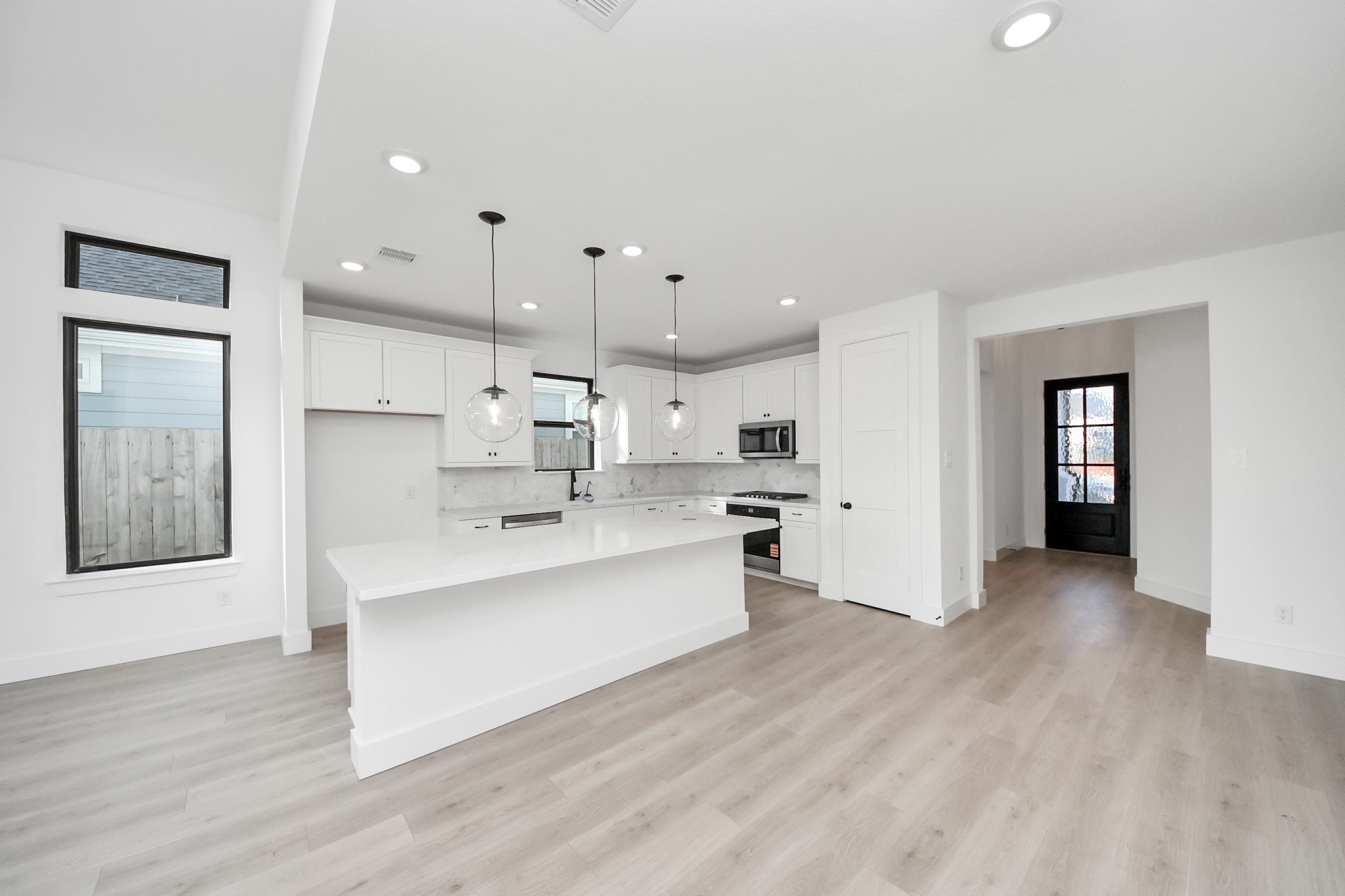 2231 Birch View Lane Katy, TX 77494 - Photo 12 of 40 a large white kitchen with a large window and stainless steel appliances