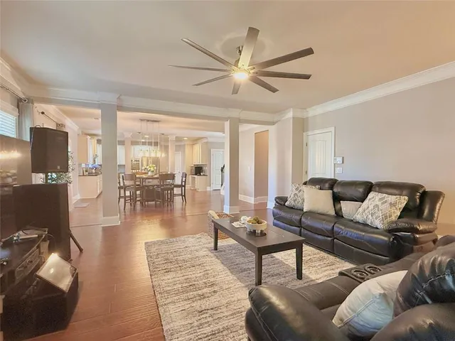 a living room with furniture and a view of kitchen