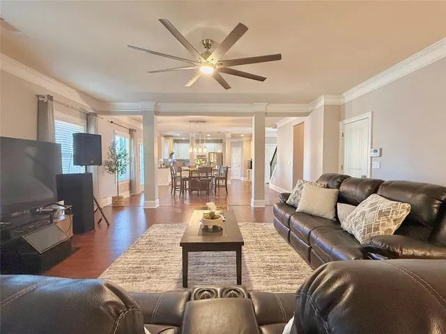 a living room with furniture and a flat screen tv with wooden floor