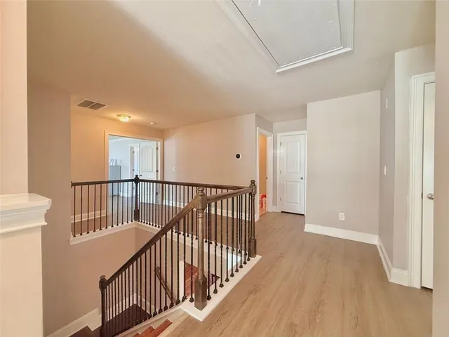 a view of a hallway with wooden floor and windows