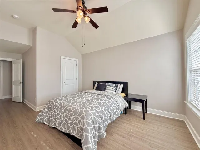 a bedroom with a bed a dresser and a window