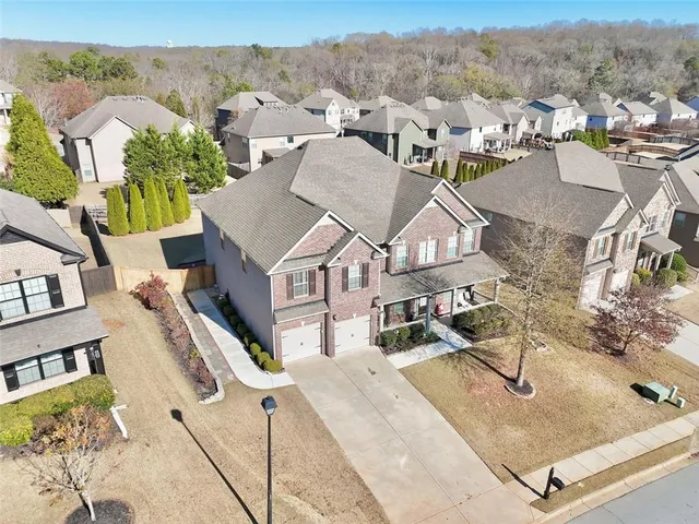 an aerial view of residential houses with outdoor space and parking
