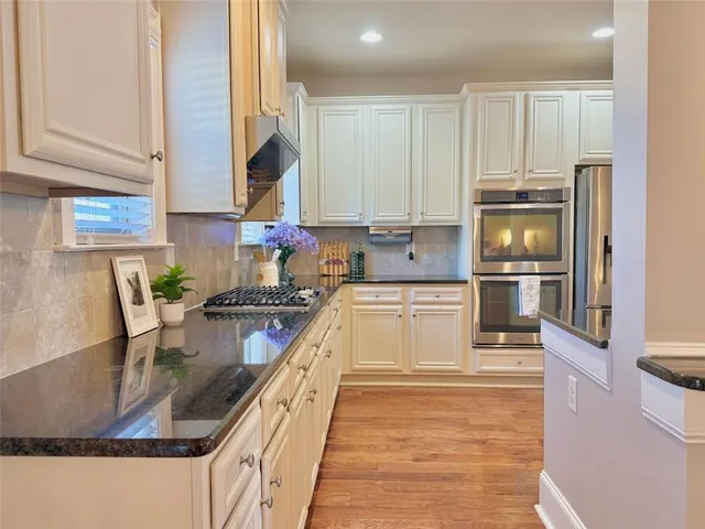 a kitchen with kitchen island granite countertop a stove a sink and a microwave