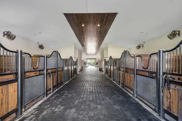 a kitchen with stainless steel appliances granite countertop a refrigerator a sink a stove and a wooden floor