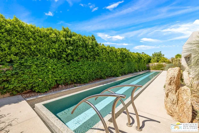 a living room with furniture a rug and a floor to ceiling window