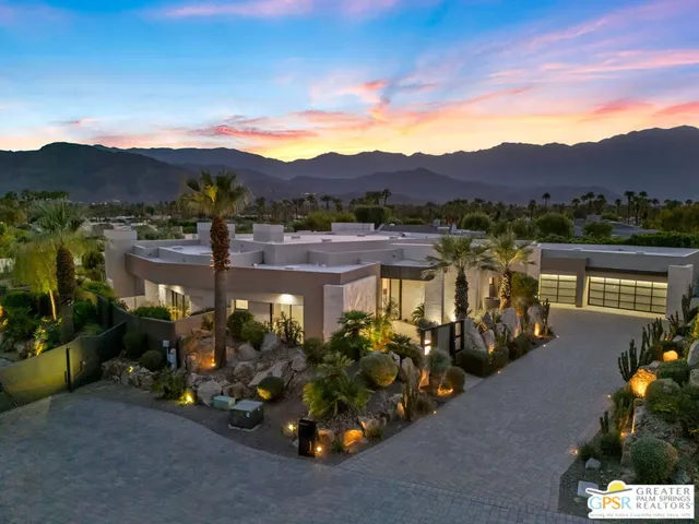 a front view of a house with a yard and potted plants