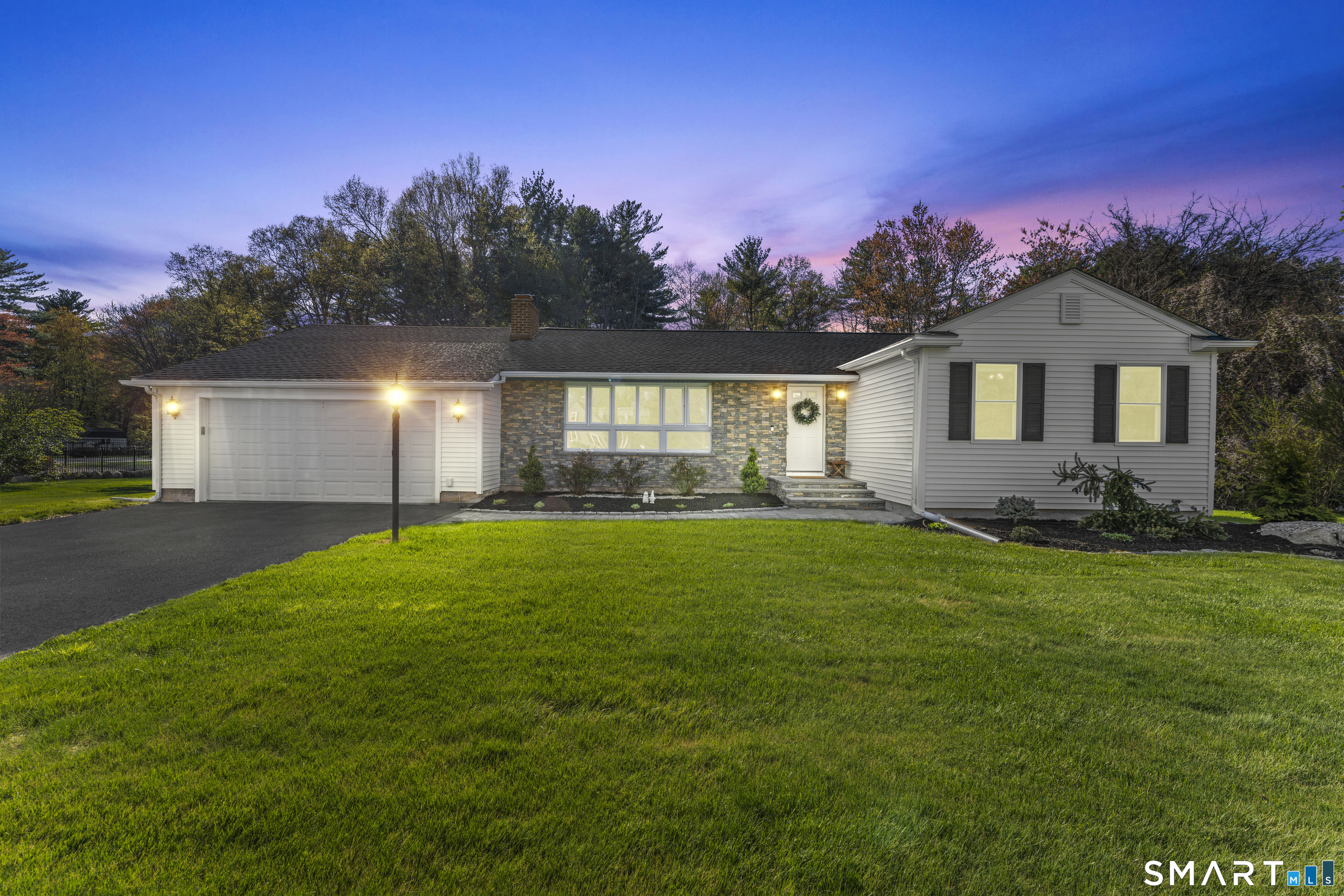 a front view of a house with a garden and yard