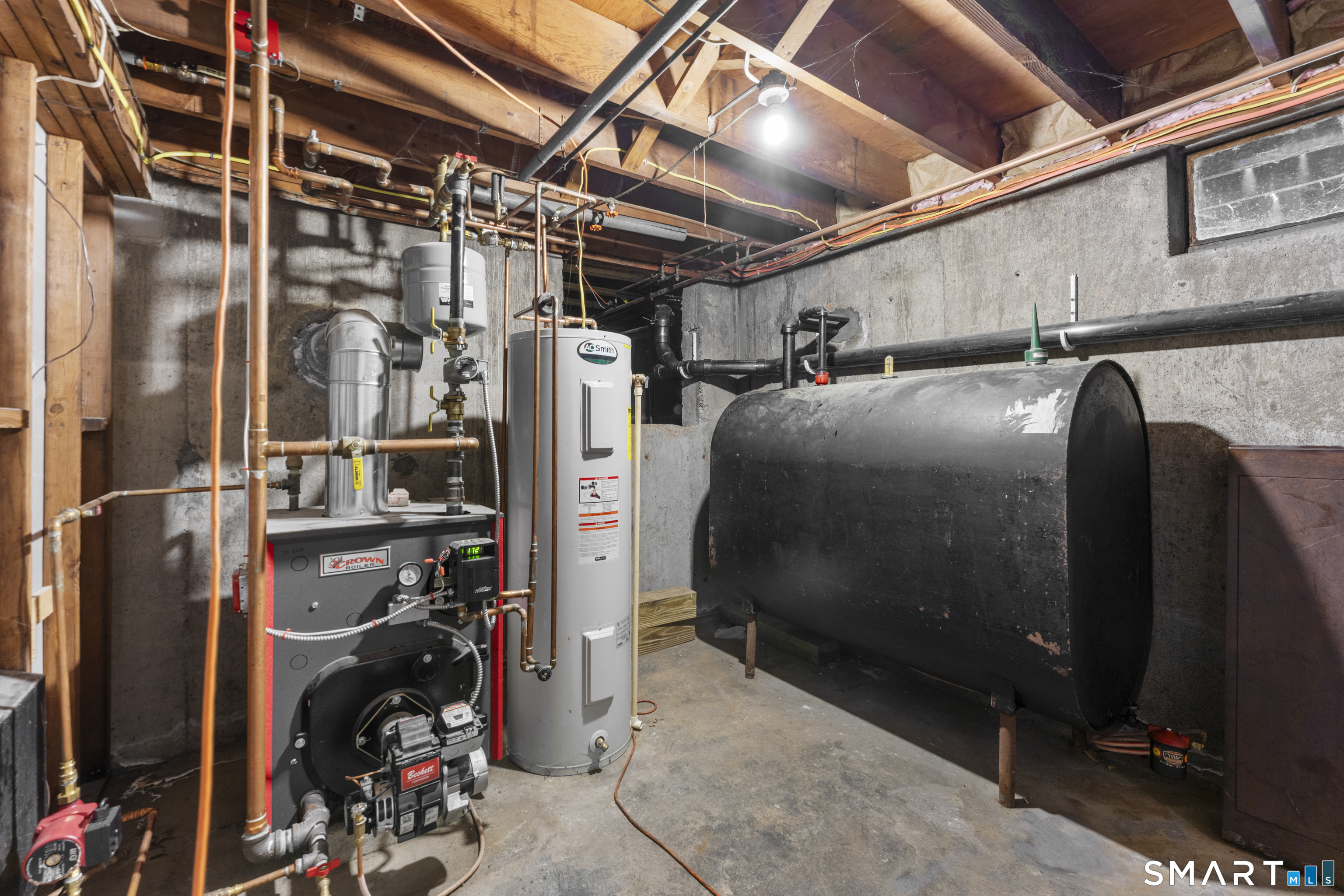 1253 North Street Suffield, CT 06078 - Photo 22 of 33 a storage room with water heater and racks