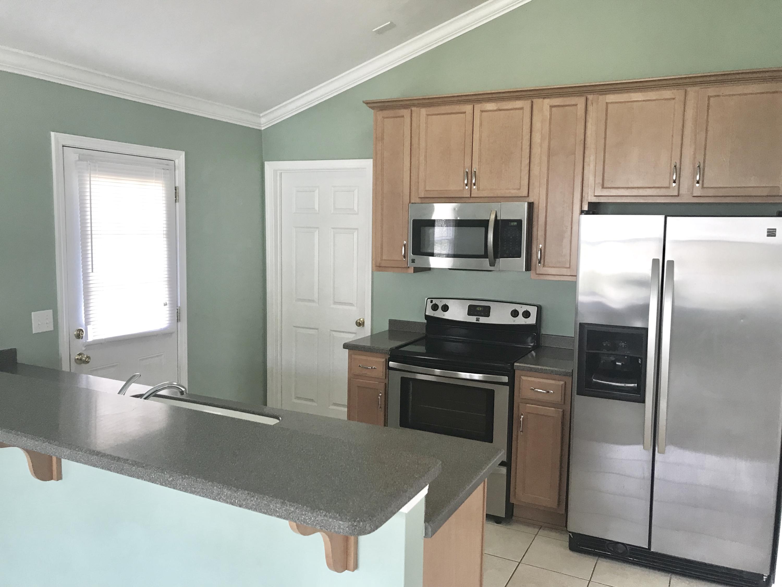 38 4th Street Santa Rosa Beach, FL 32459 - Photo 8 of 22 a kitchen with granite countertop a refrigerator stove and microwave