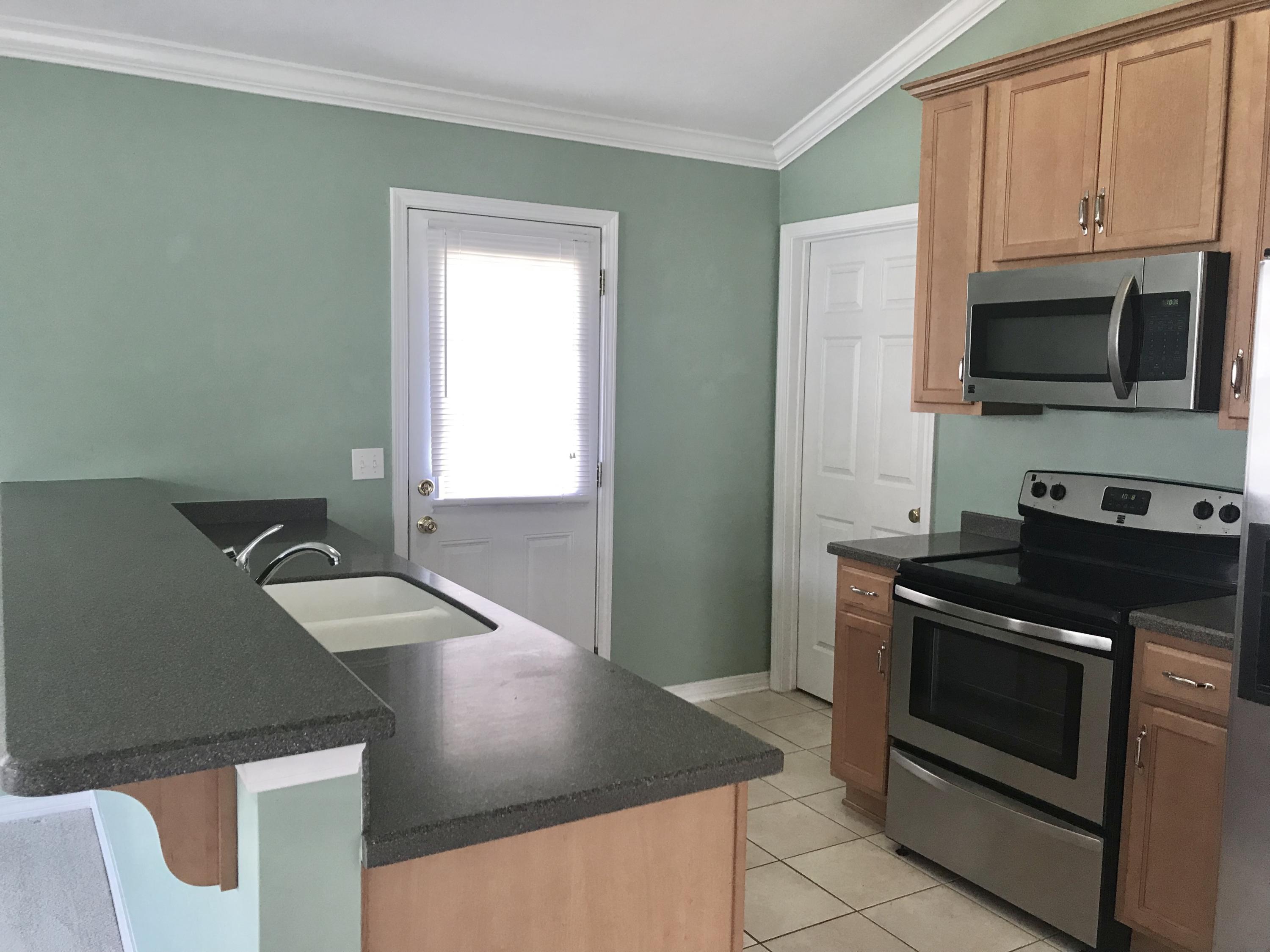 38 4th Street Santa Rosa Beach, FL 32459 - Photo 9 of 22 a kitchen with stainless steel appliances granite countertop a stove a microwave and a refrigerator