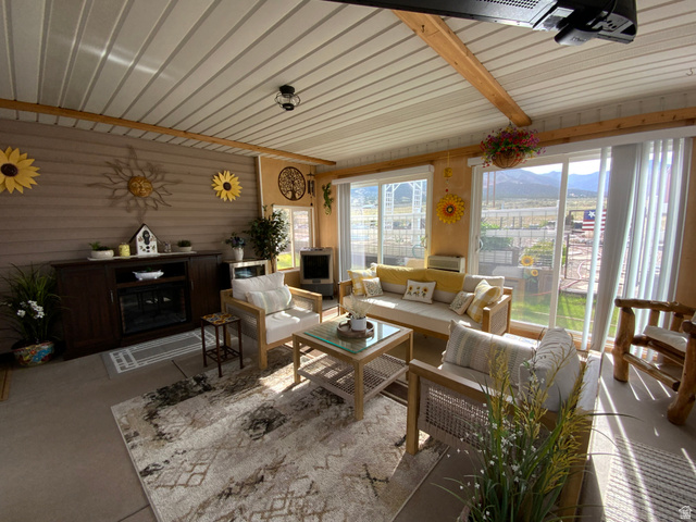 1061 Copper Street Stockton, UT 84071 - Photo 23 of 43 Sunroom with exposed wood beams, a built-in electric fireplace, and extensive glass sliding doors