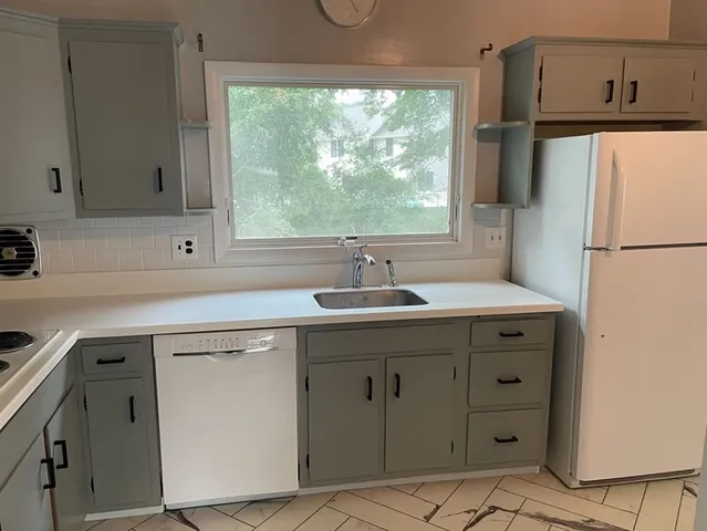 a kitchen with a sink a refrigerator a window and a cabinets