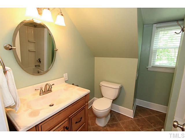 308 Colleton Road Raleigh, NC 27610 - Photo 12 of 25 a bathroom with a toilet sink vanity and mirror