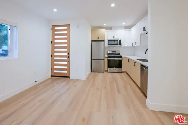 a kitchen with stainless steel appliances a refrigerator and a stove top oven