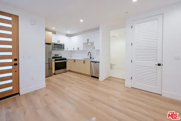 a view of kitchen with wooden floor and electronic appliances