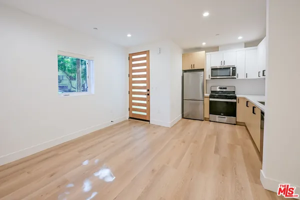 a kitchen with stainless steel appliances kitchen island granite countertop a refrigerator and a stove top oven