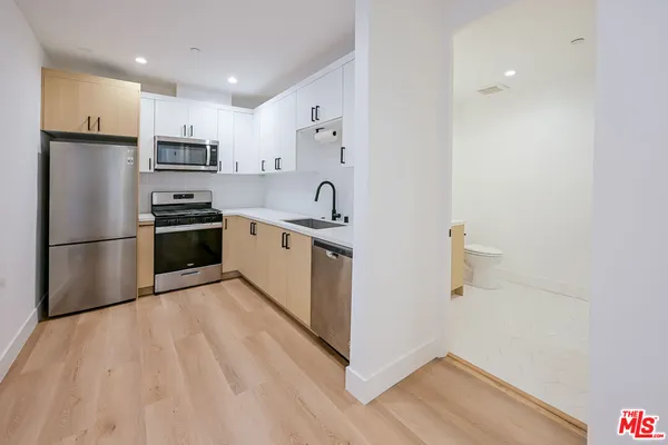 a kitchen with stainless steel appliances granite countertop a refrigerator sink and stove
