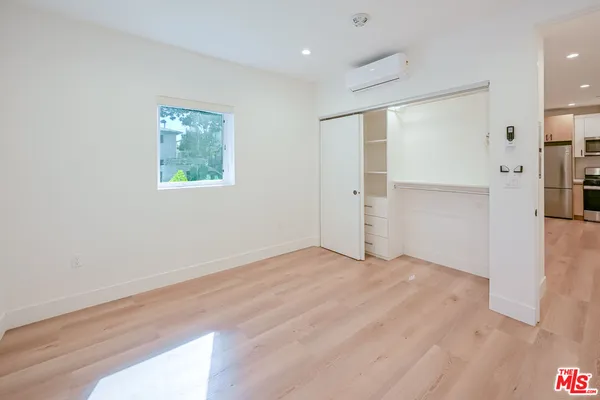 a view of an empty room with closet and a window