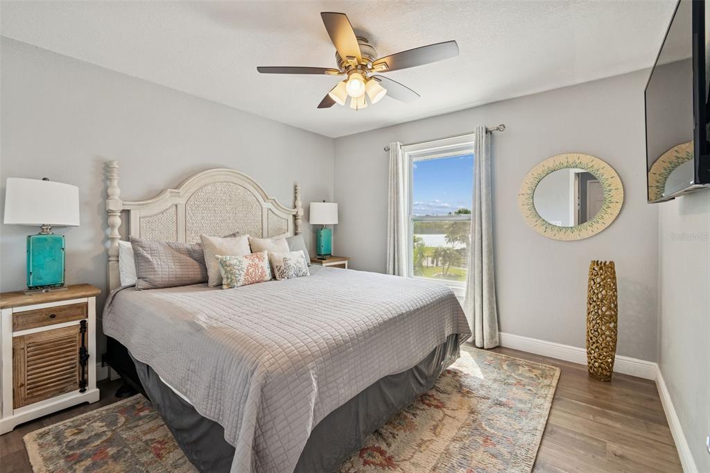 330 6th Avenue Indian Rocks Beach, FL 33785 - Photo 12 of 52 a bedroom with a bed a mirror and a chandelier