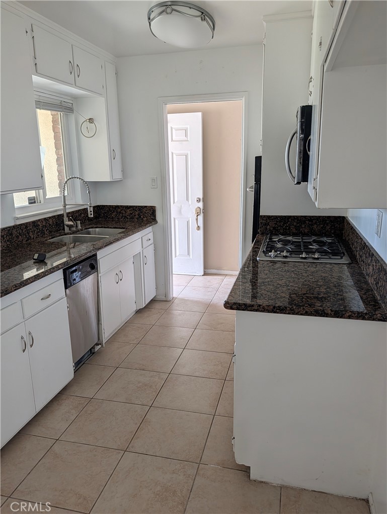 8641 Garfield Street Riverside, CA 92504 - Photo 3 of 19 a kitchen with granite countertop a sink a stove and cabinets