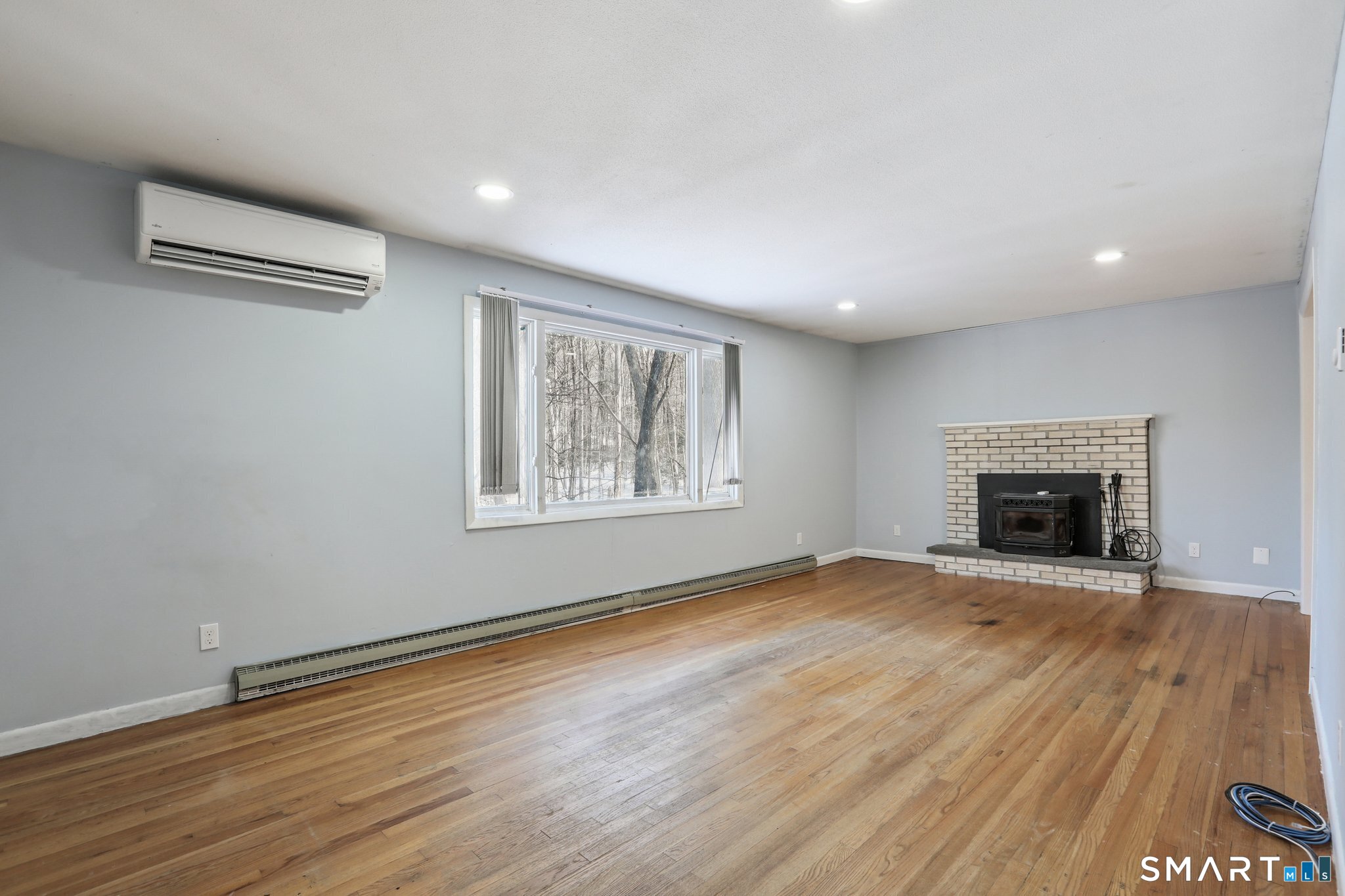 643 Bucks Hill Road Southbury, CT 06488 - Photo 2 of 25 a view of an empty room with wooden floor fireplace and a window