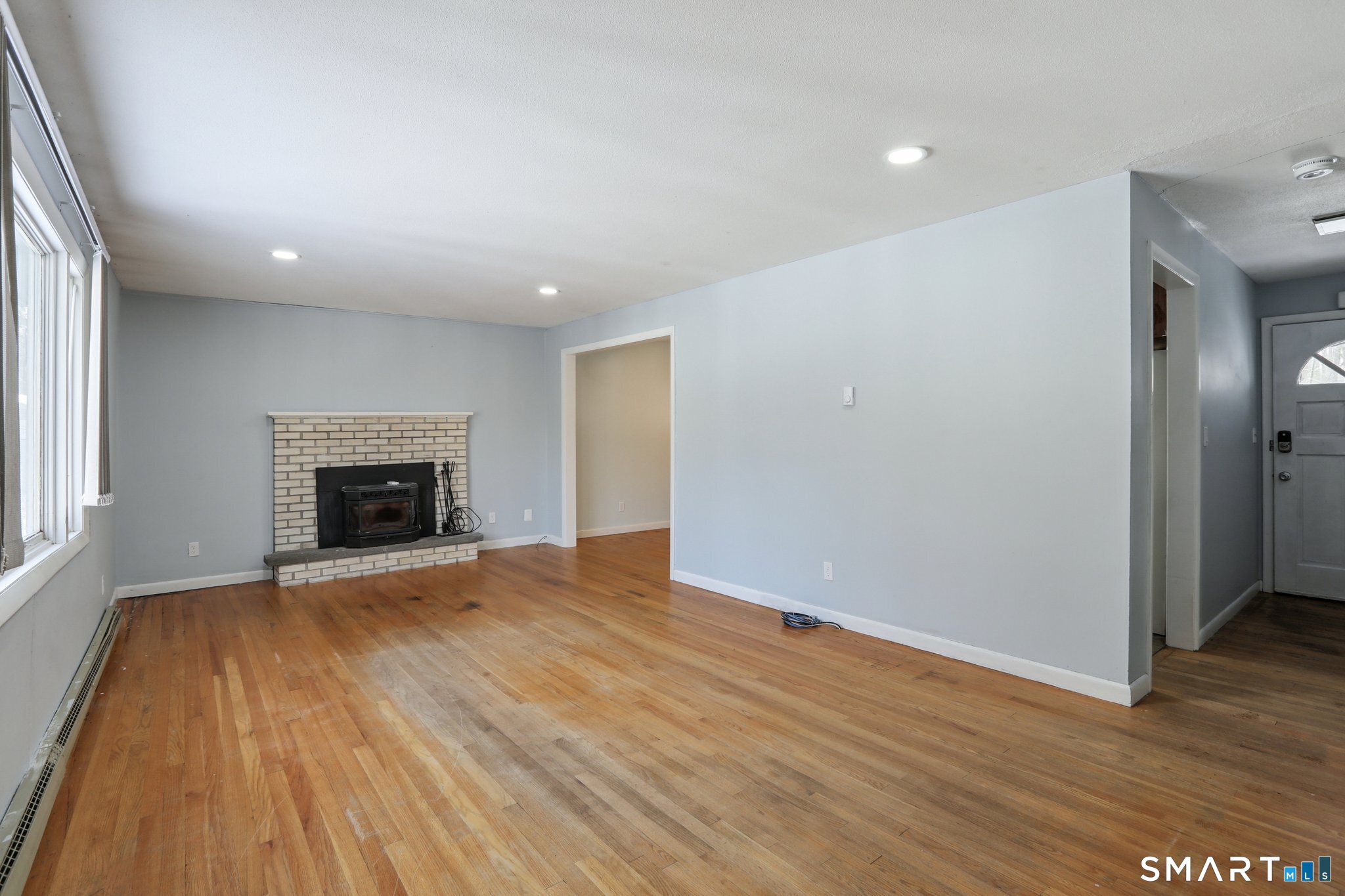 643 Bucks Hill Road Southbury, CT 06488 - Photo 3 of 25 an empty room with wooden floor and fireplace
