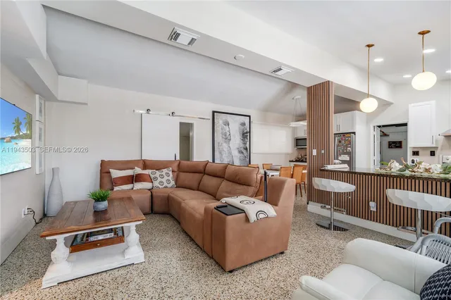 a living room with furniture a rug and white walls