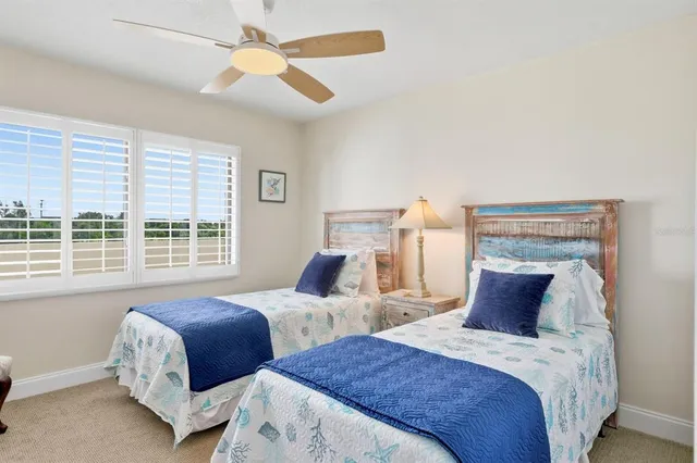 a bedroom with two beds and a large window