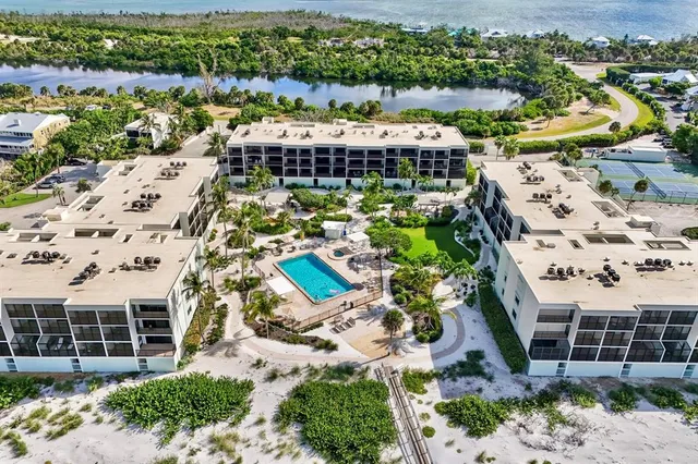 an aerial view of a house with a garden and lake view