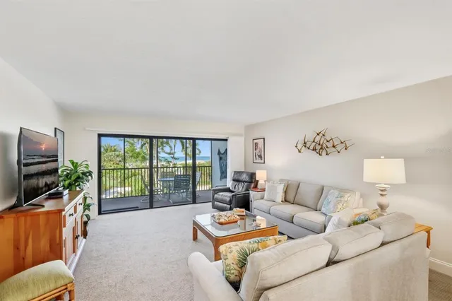 a living room with furniture a flat screen tv and a floor to ceiling window