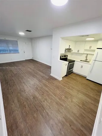 a kitchen with a sink cabinets and wooden floor