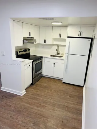 a kitchen with stainless steel appliances a refrigerator sink and white cabinets