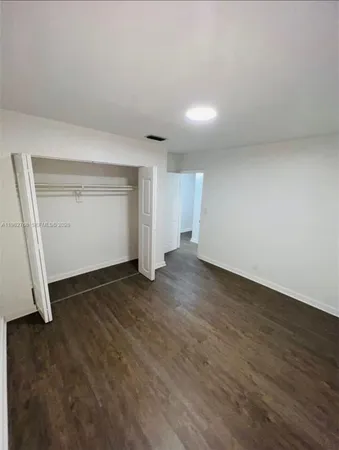 an empty room with wooden floor and closet