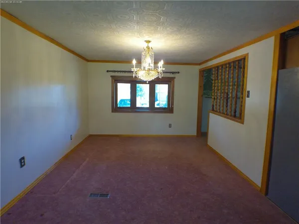 an empty room with windows and chandelier