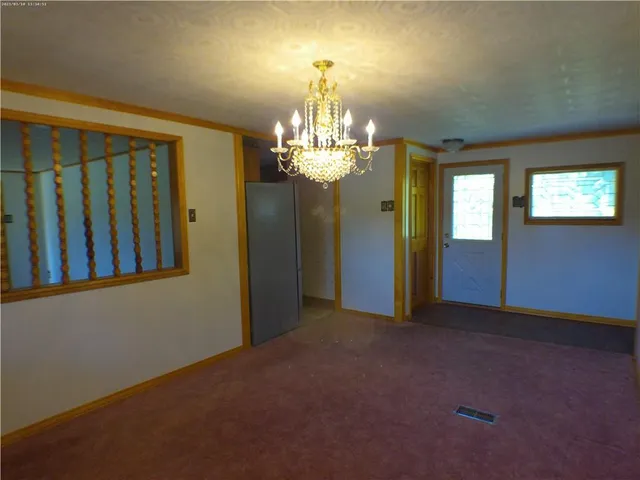 a view of a hallway with windows and chandelier