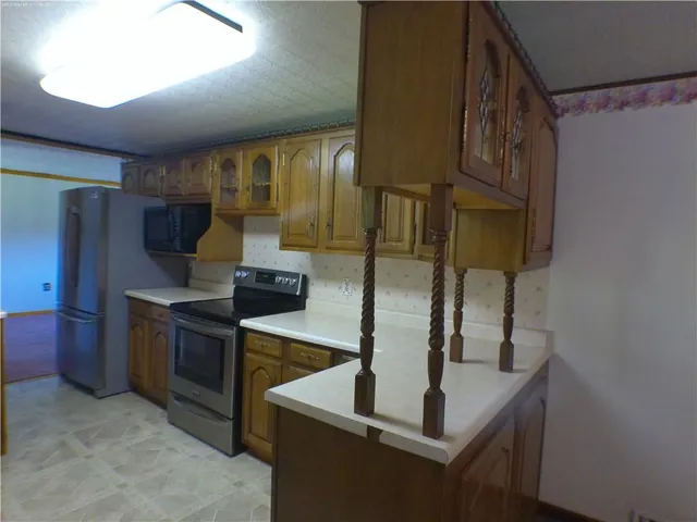 a kitchen with stainless steel appliances granite countertop a sink and a refrigerator