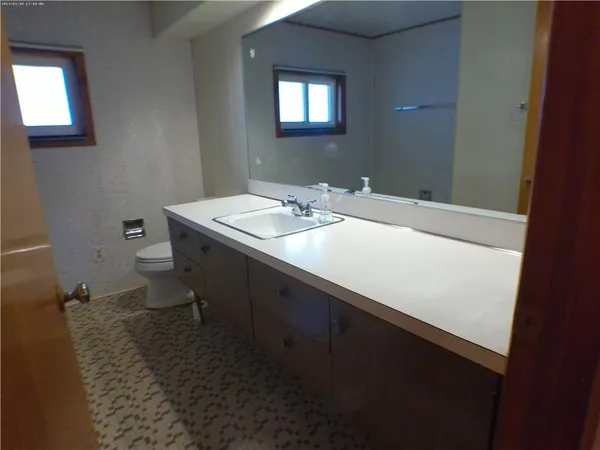 a bathroom with a sink toilet and a mirror