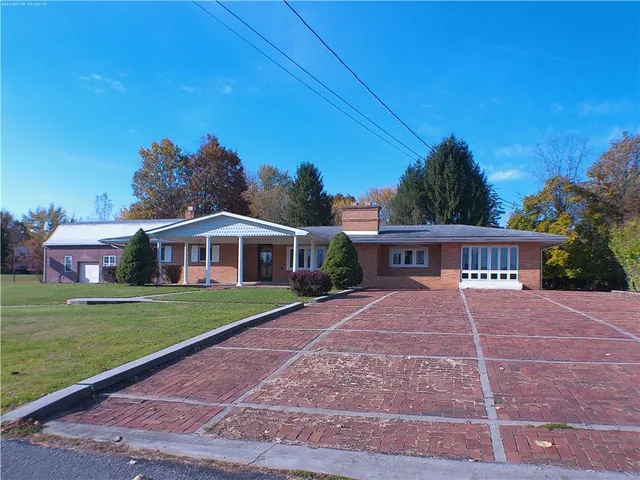 a view of a big house with a big yard and palm trees
